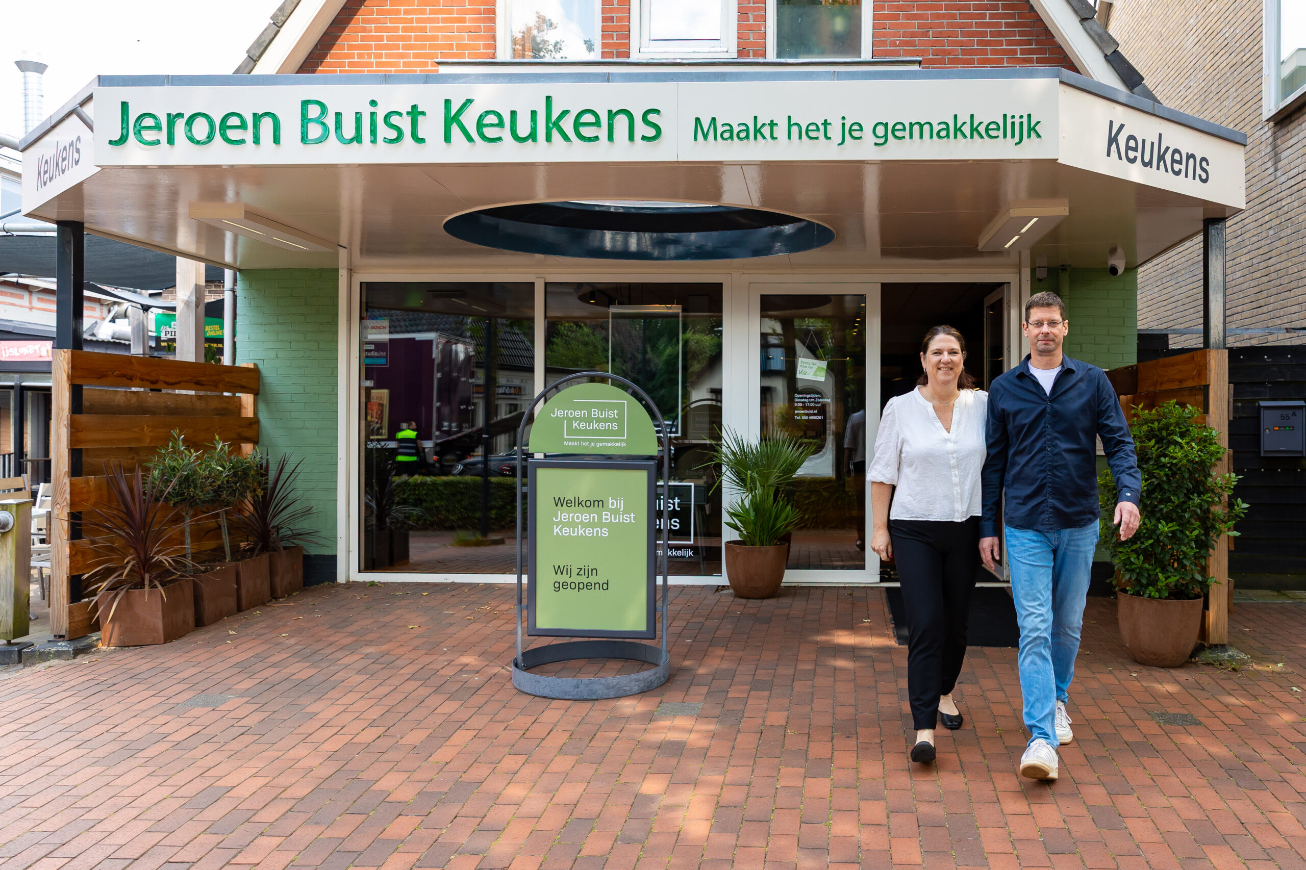 Gesneden rode ui op houten plank naast fles olijfolie op donker werkblad.
